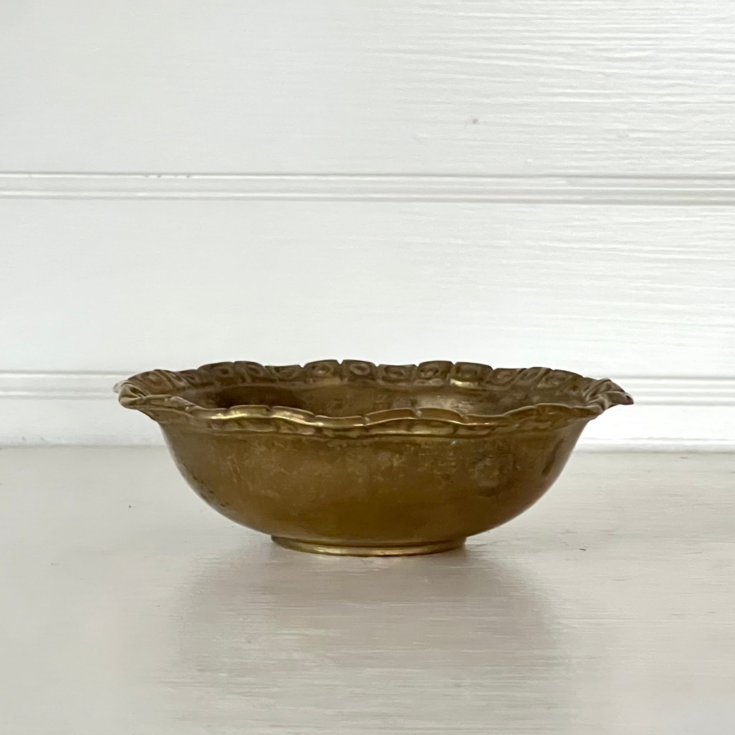 Bronze bowl on a white surface with a light gray background