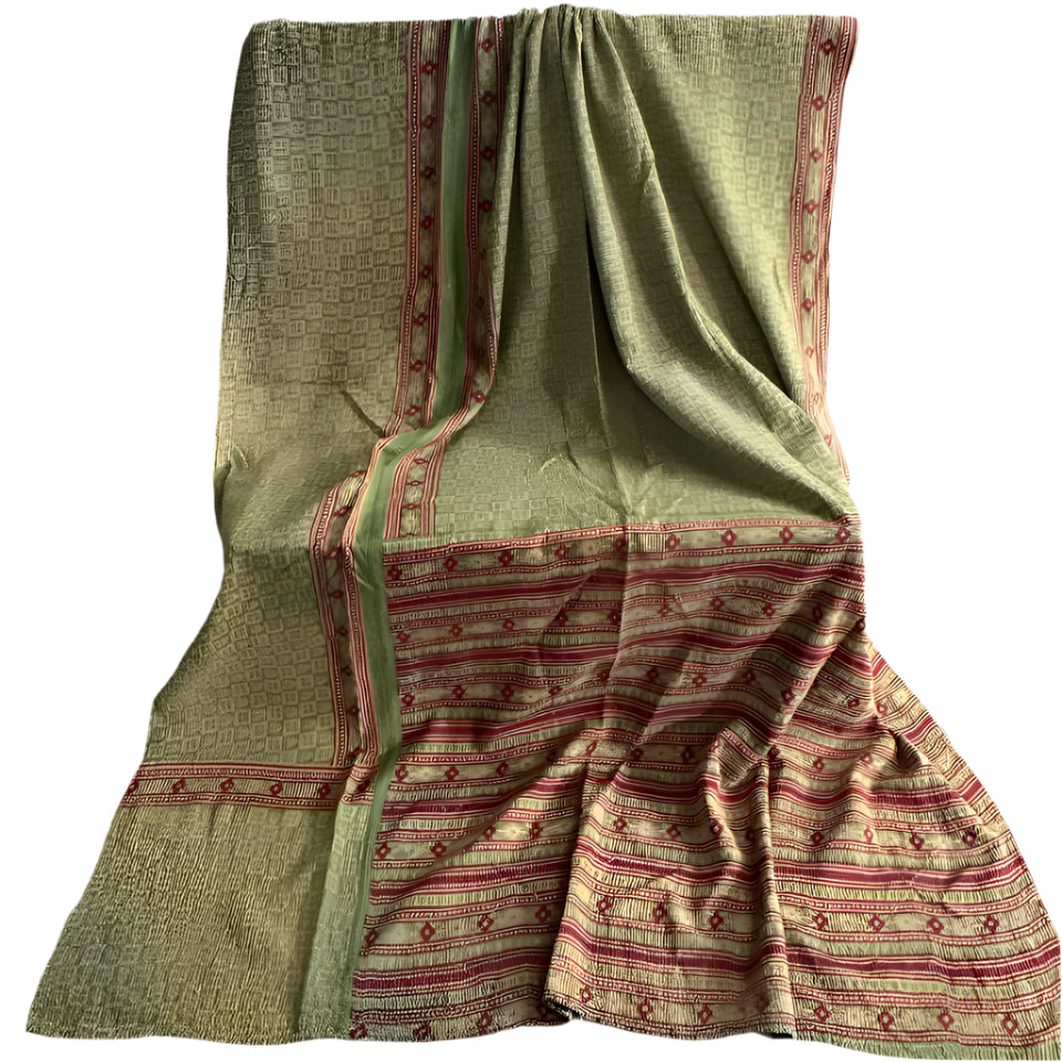 Traditional patterned fabric draped over a surface with a plain background
