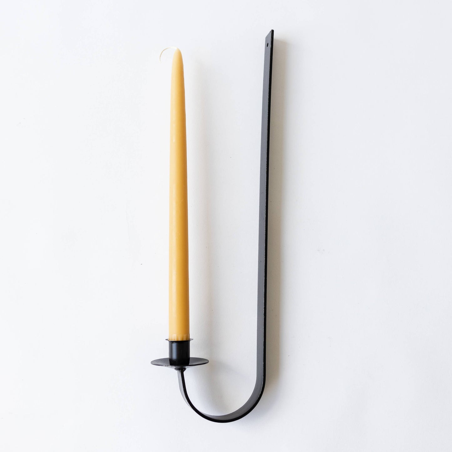 Iron candle holder with a yellow candle on a white background
