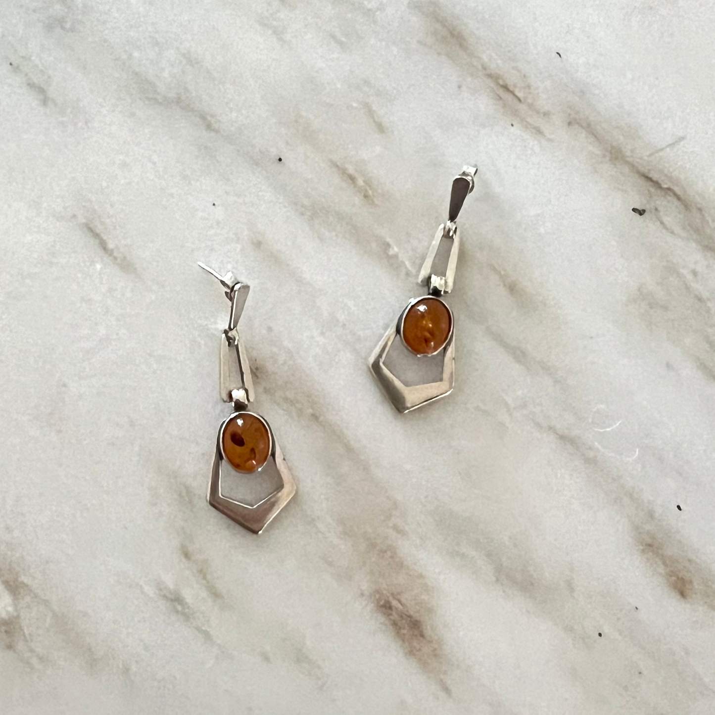 Amber and Sterling Dangle earrings on a marble background