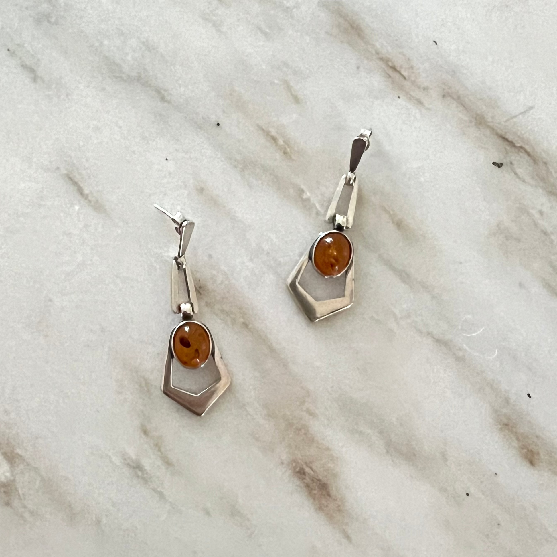 Amber and Sterling Dangle earrings on a marble background