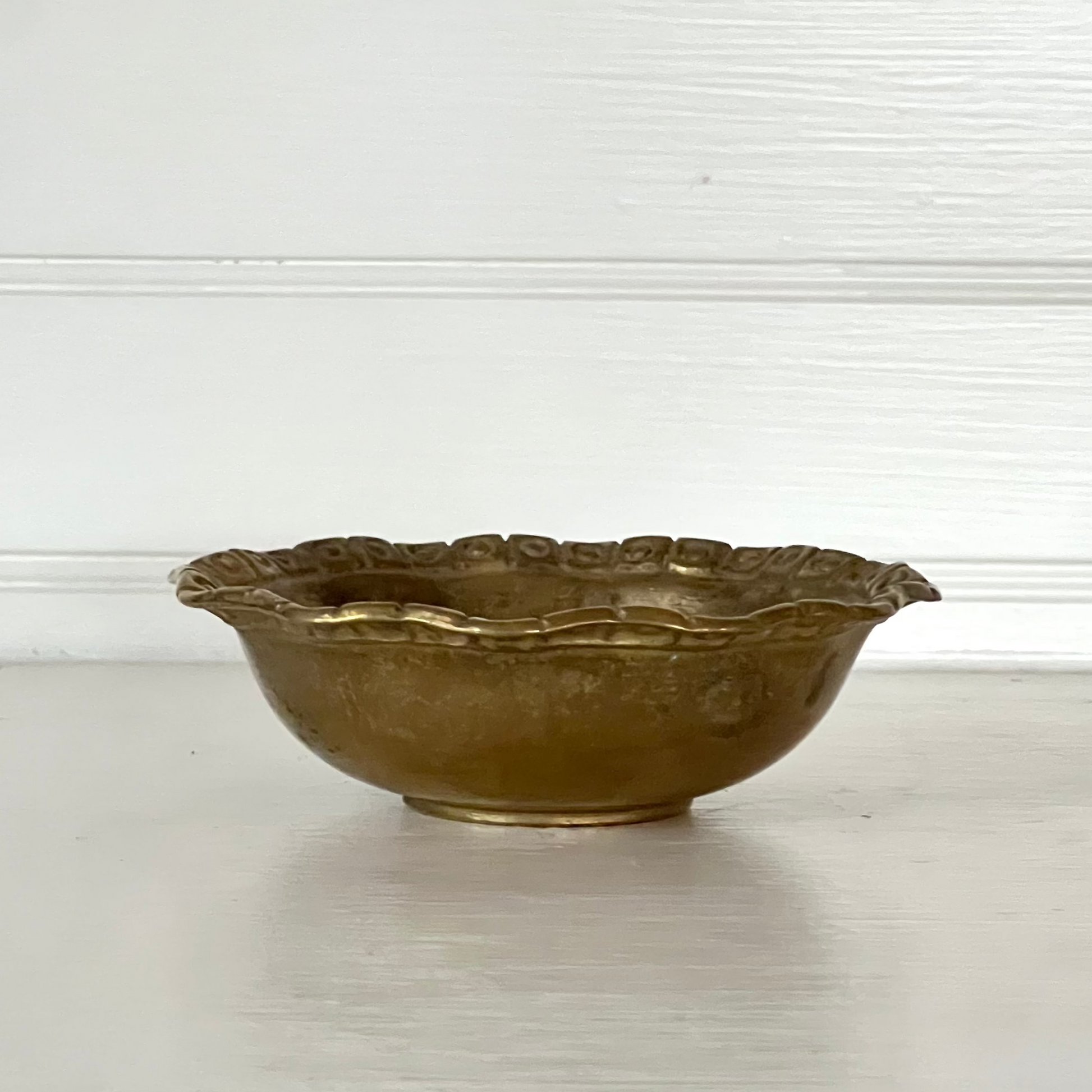 Bronze bowl on a white surface with a light gray background