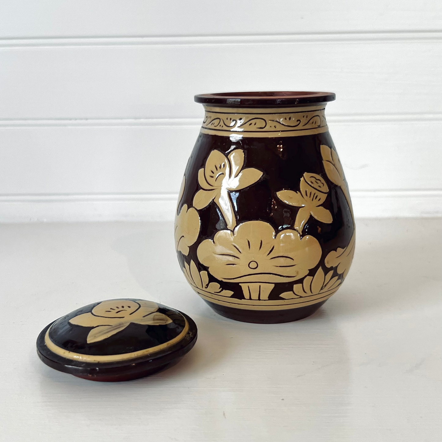 Ceramic jar with floral design on a white background