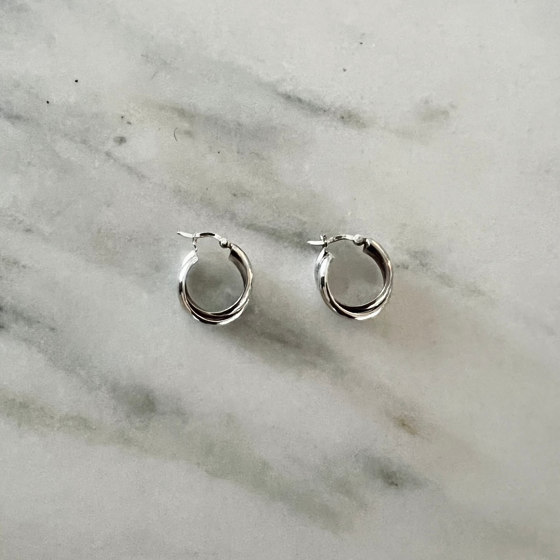 Silver hoop earrings on a marble surface