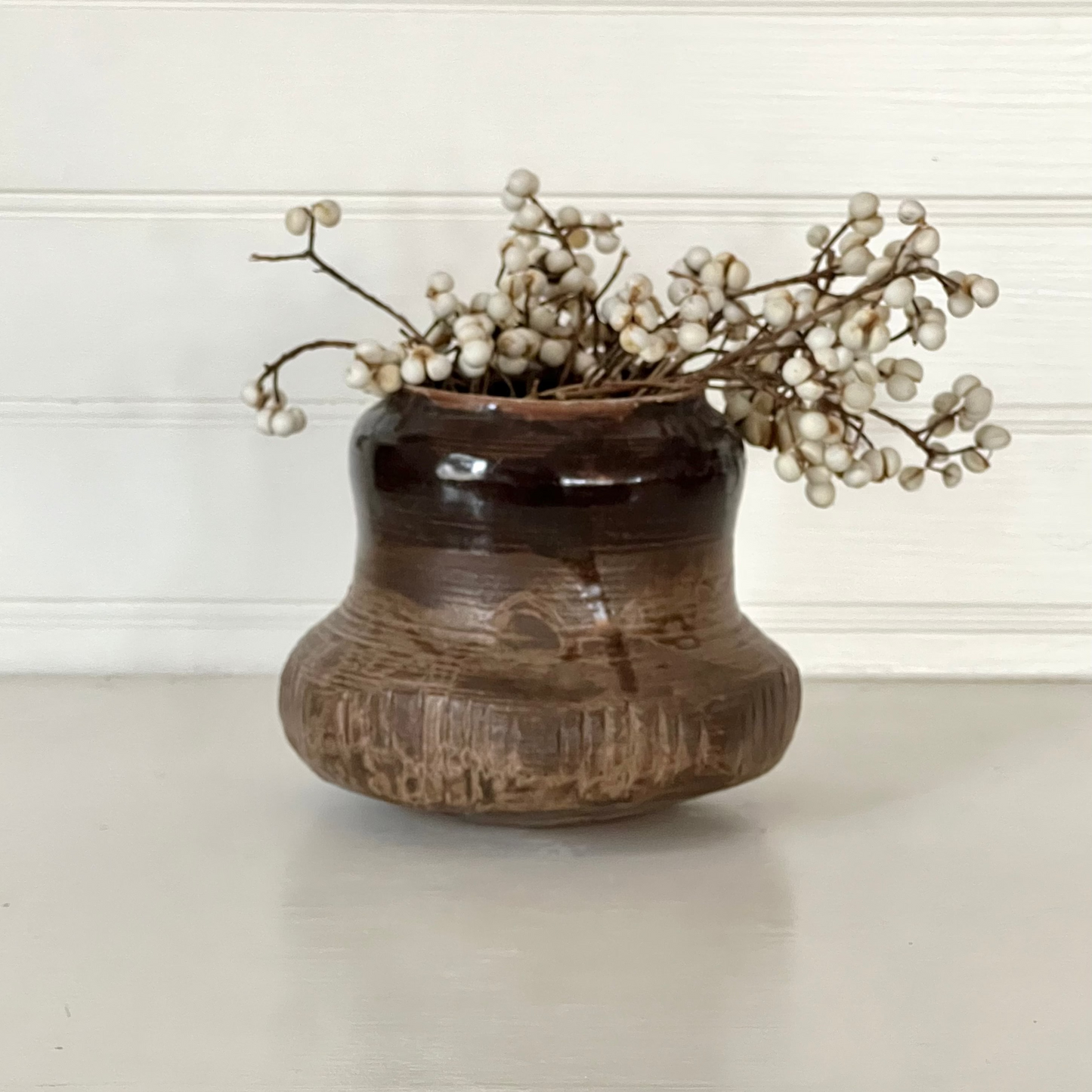 Decorative vase with dried flowers on a neutral background