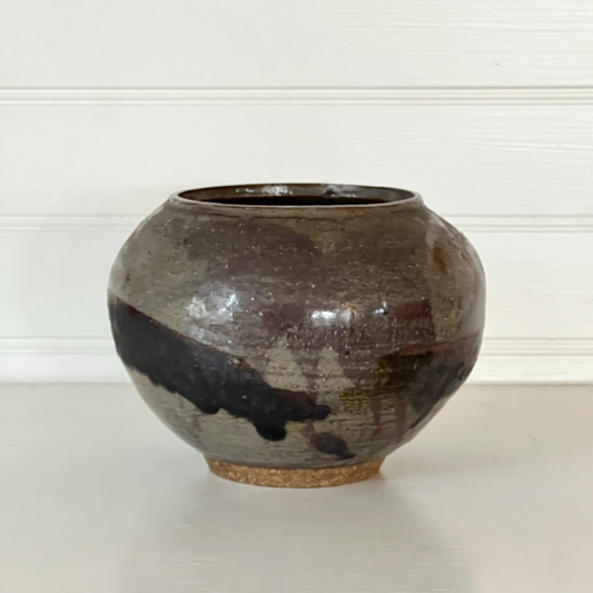 Brown ceramic vase on a white surface with a white background