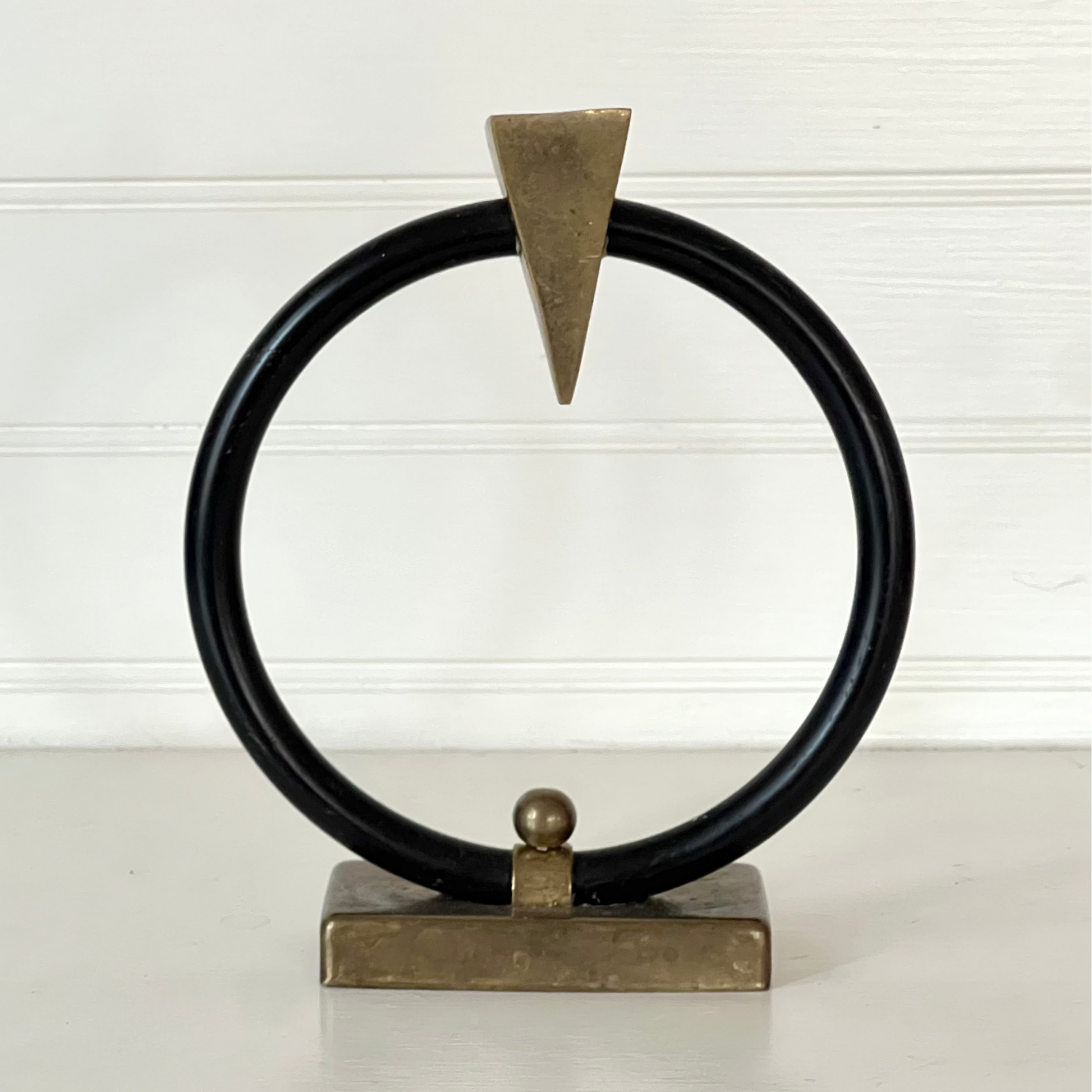 Decorative object with black circular design and gold accents on a white background