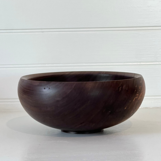 Wooden bowl on a light surface with a white background