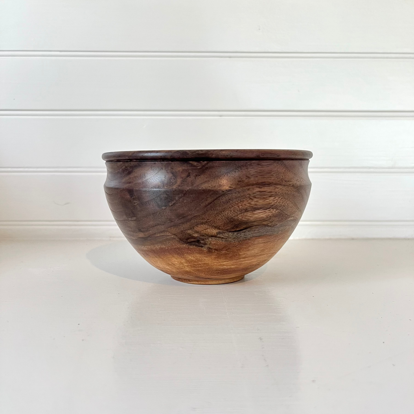 Wooden bowl on a white surface with a white background