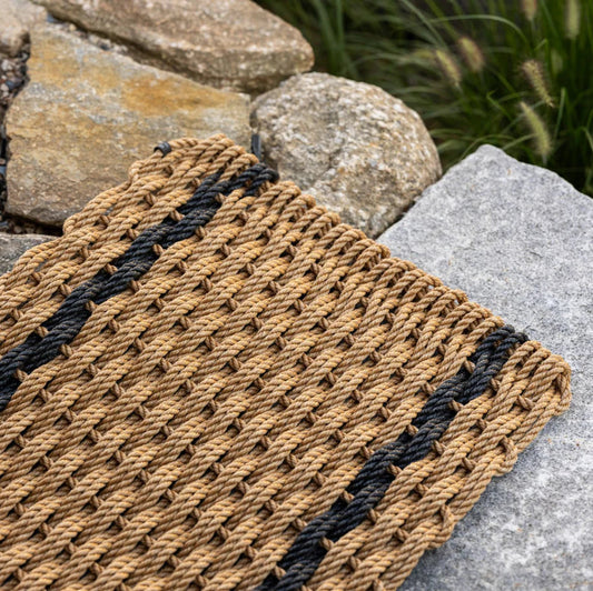 Woven mat with black stripes on a stone surface
