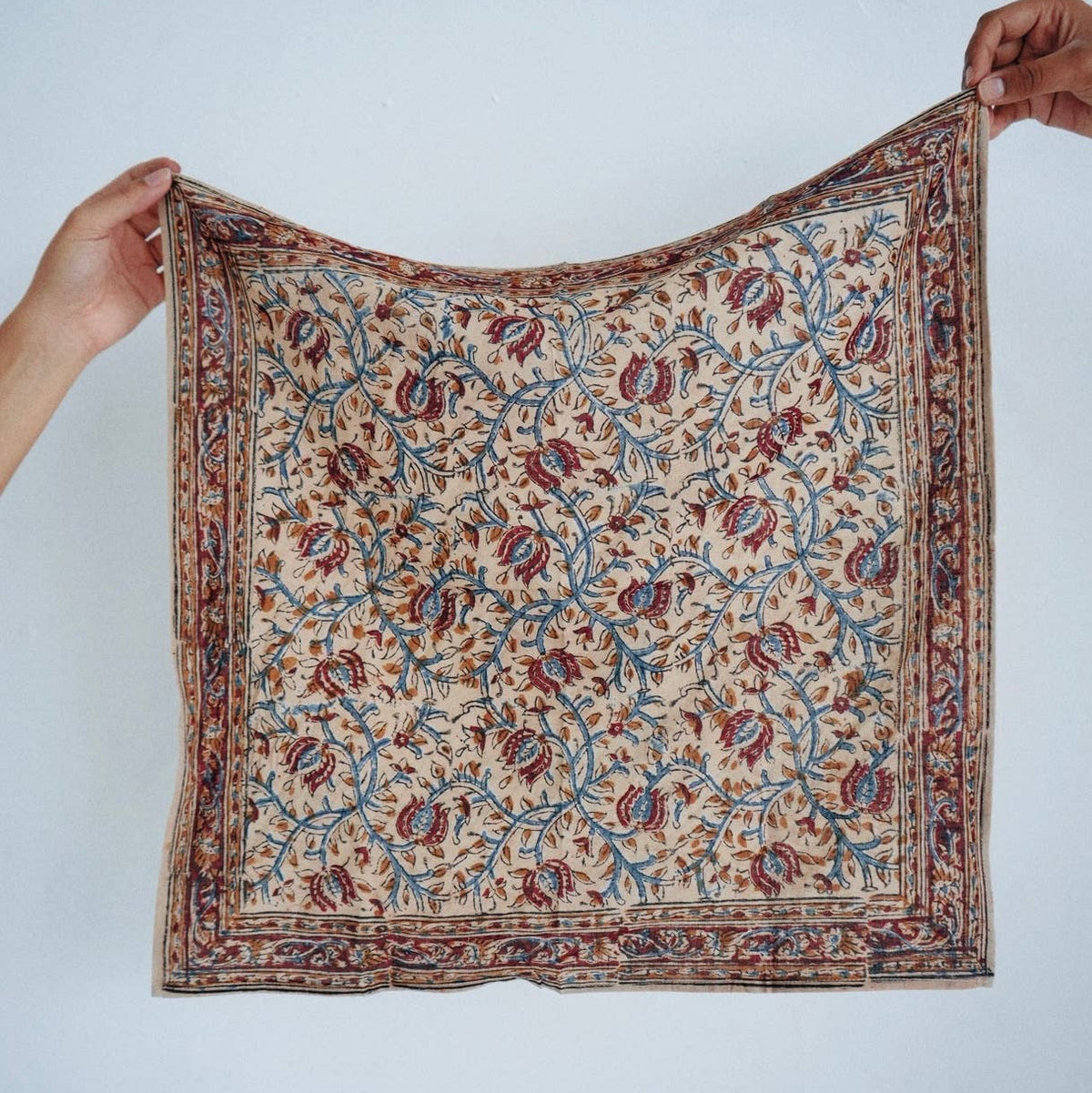 Person holding a patterned fabric against a white background