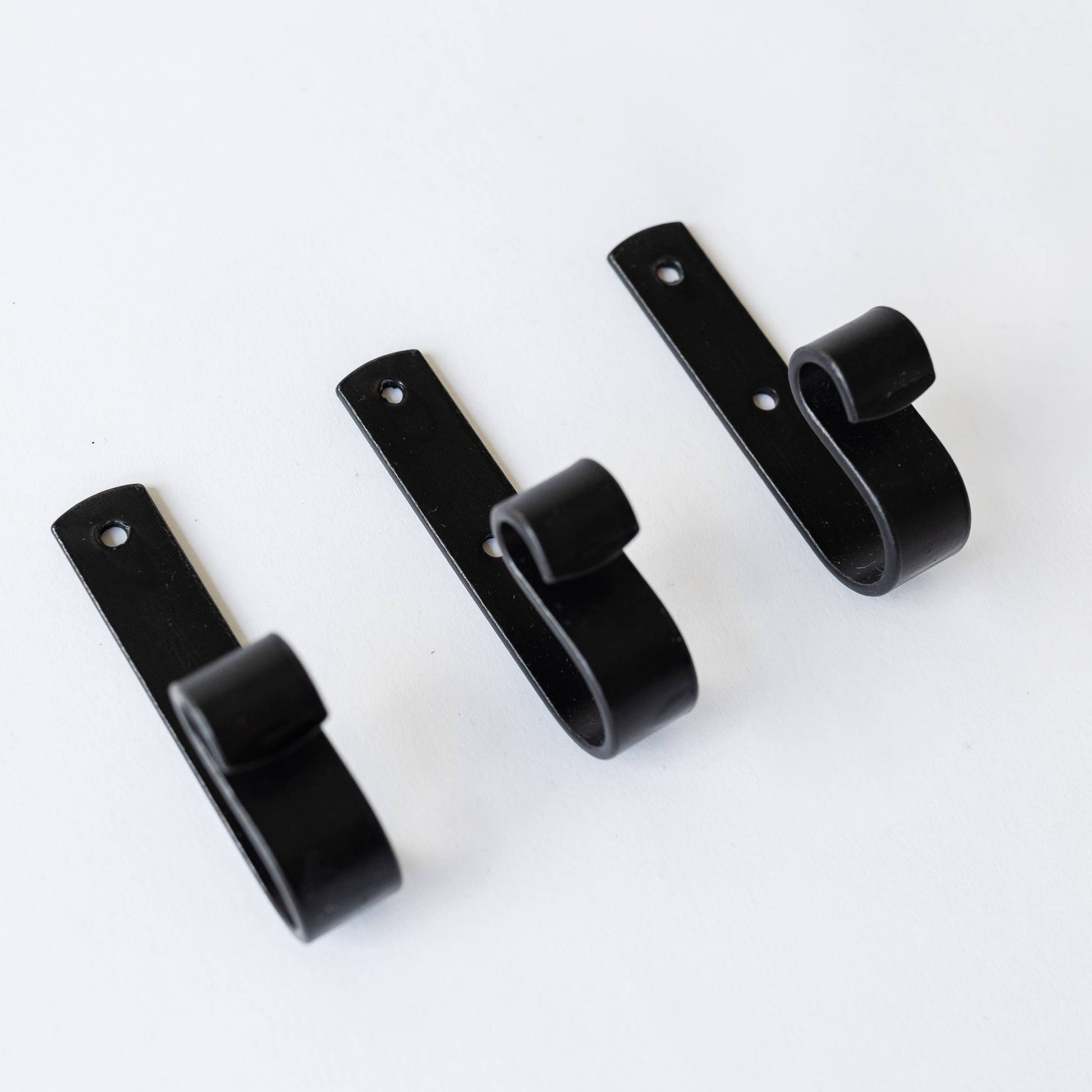 Set of black curtain hooks on a white background