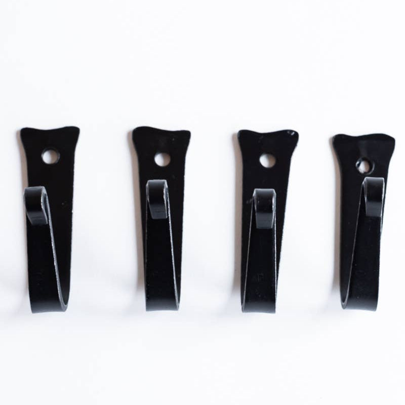 Four black wall hooks on a white background