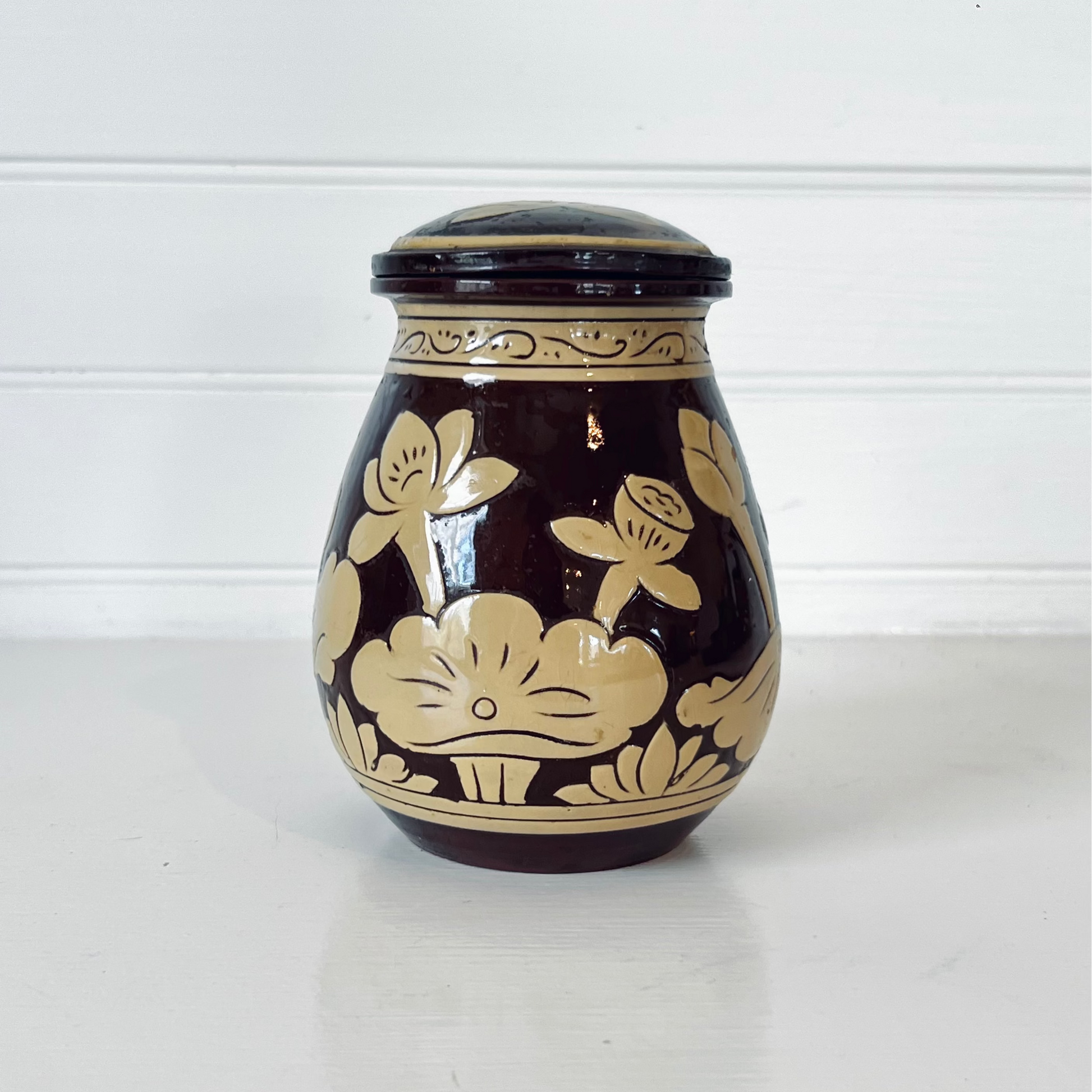 Ceramic jar with floral design on a white background