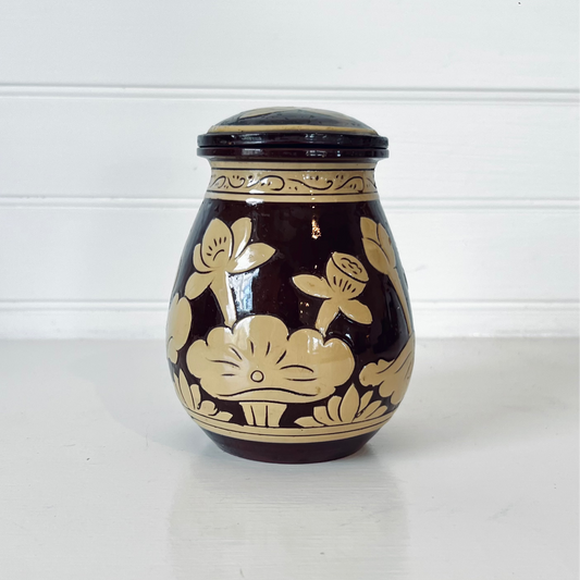 Ceramic jar with floral design on a white background