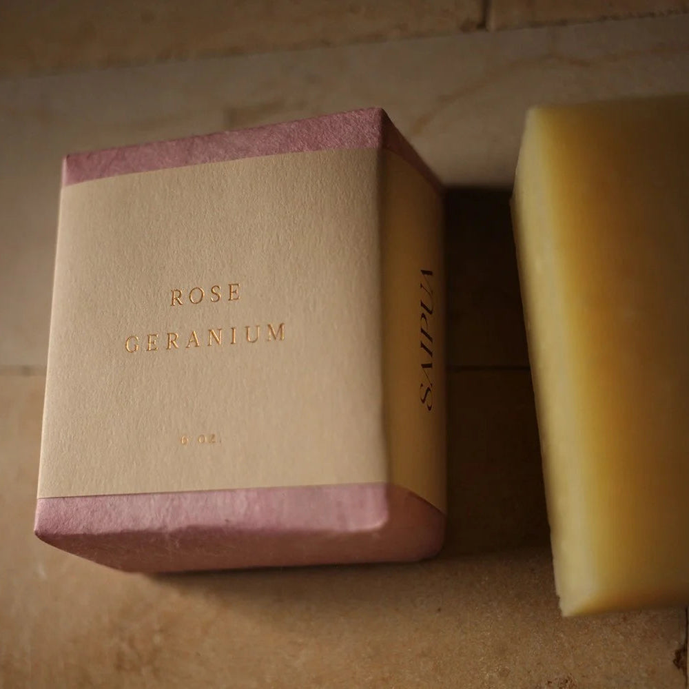 Bar of soap with a 'Rose Geranium' box on a wooden surface