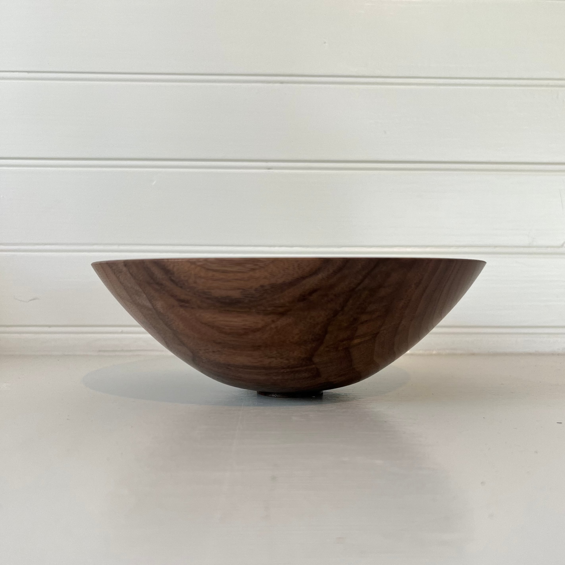 Wooden bowl on a white surface with a white background