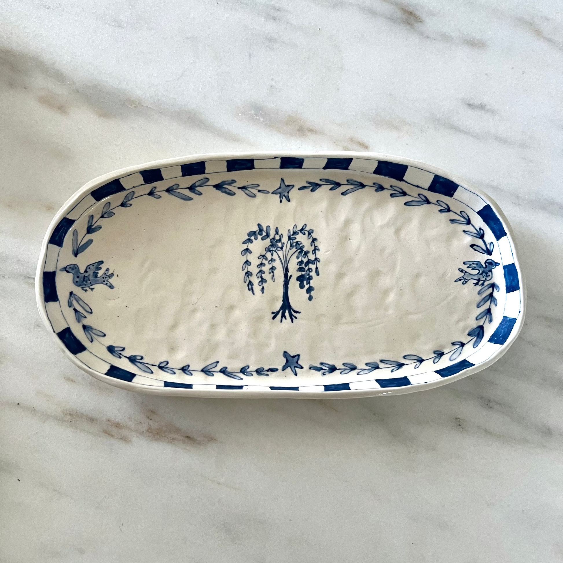 Ceramic platter with blue floral patterns on a marble surface